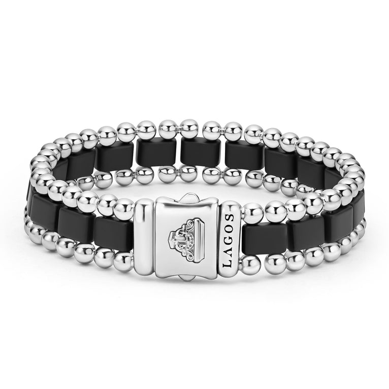 A back-view of a stainless steel bracelet in the middle of a white background featuring matte black ceramic and caviar beading.