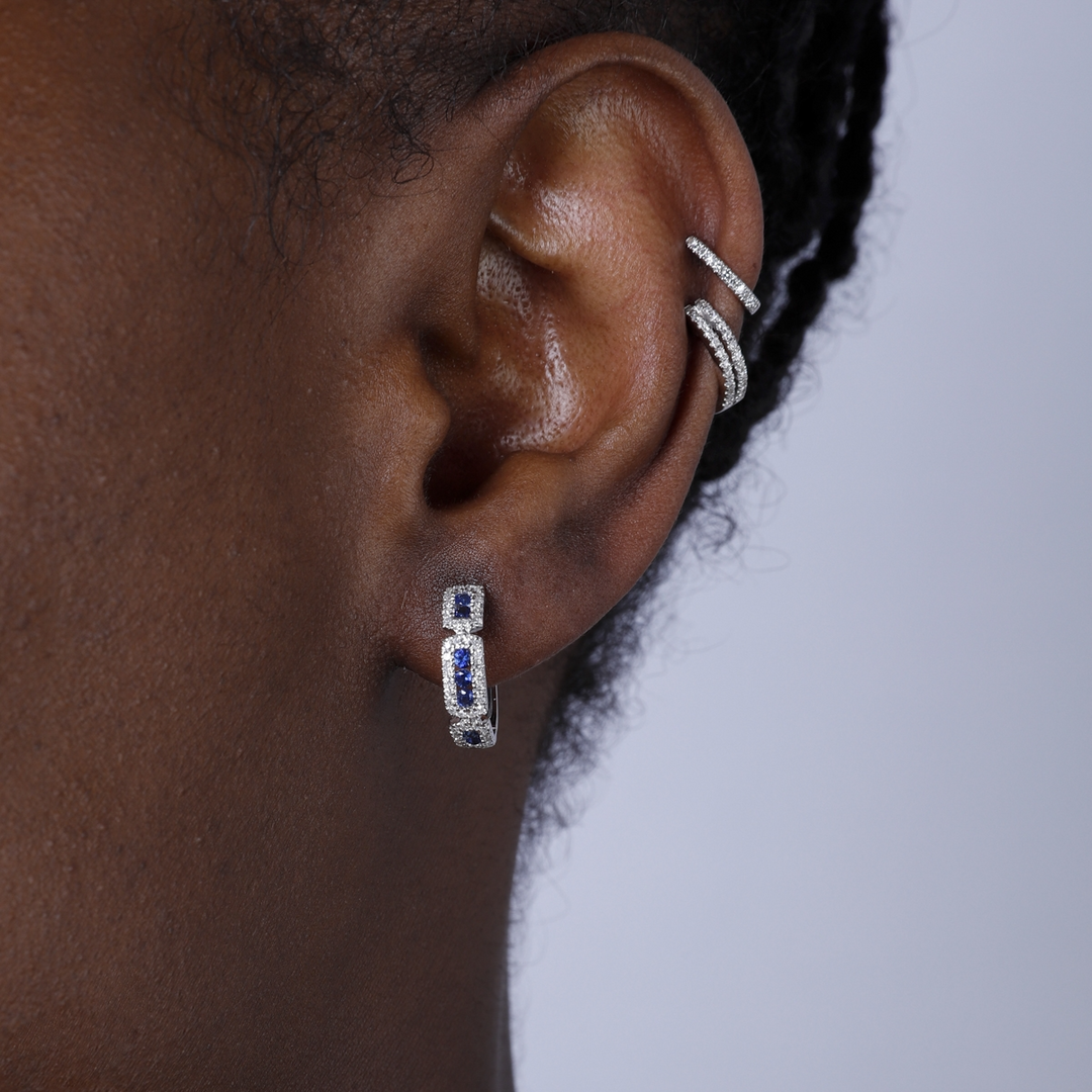 A close-up of a woman's ear wearing 14k White Gold Hoop Earrings with stationed round diamonds.