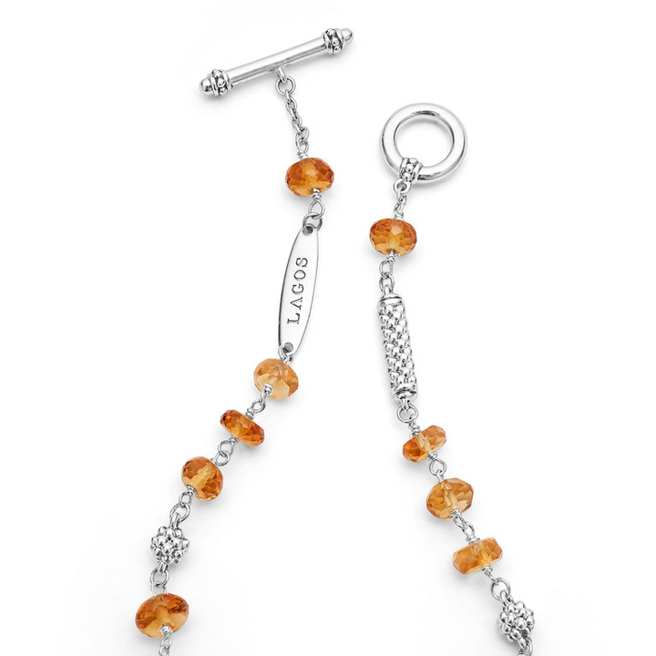 A sterling silver bracelet is displayed in the middle of a white background, focusing on the clasp, featuring citrine ceramic and sterling silver Caviar beads.