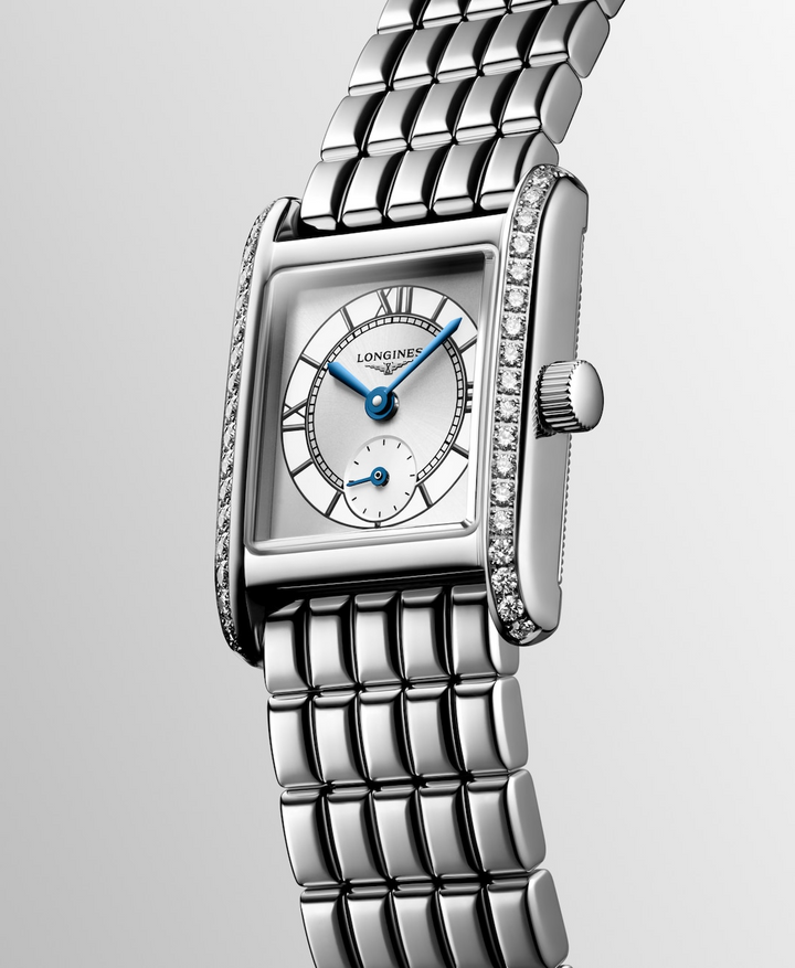 A Longines watch is displayed in the middle, tilted to the left on a white background. The rectangular-shaped watch features a white dial, blue hands, black markers, a stainless steel diamond-set bezel, and a stainless steel bracelet.