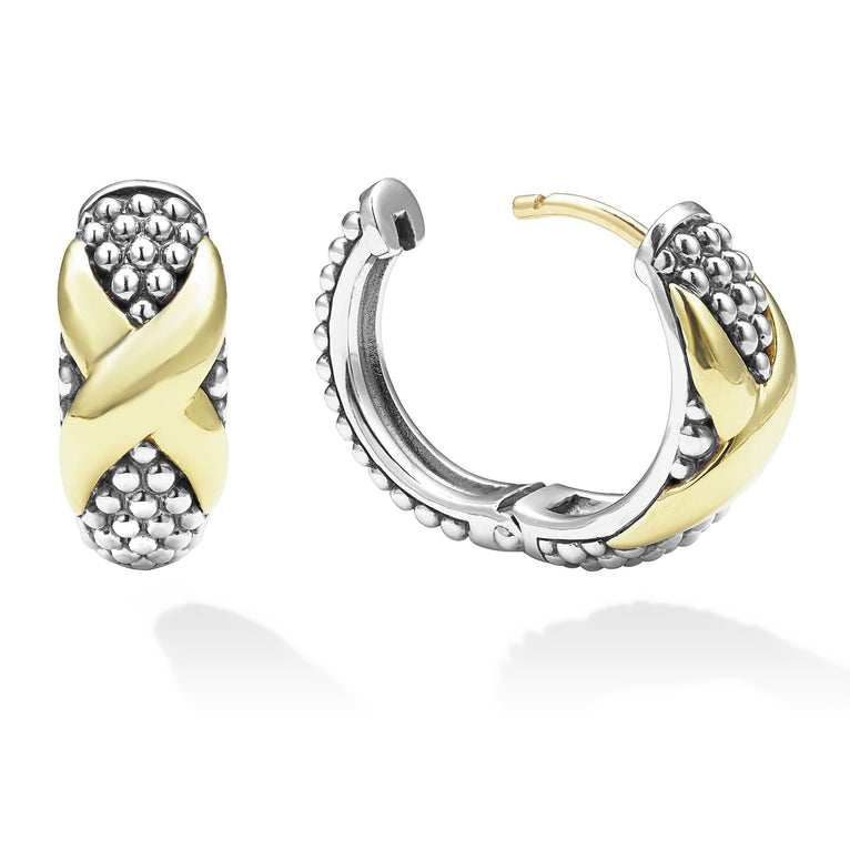 A pair of two-tone huggie earrings with Smooth 18k gold and sterling silver Caviar beading and an x motif. The right earring is angled to the side, unclasped.