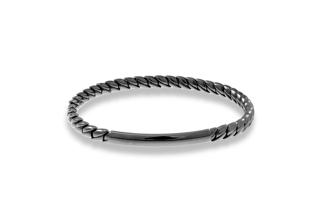 A Black Gold Stretch Bar Bracelet sitting in the middle of a white background. The bracelet features a sleek bar design and an unique and edgy twist. 