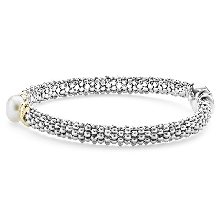 A side-view of a sterling silver bracelet in the middle of a white background featuring a freshwater cultured pearl framed by two 18K gold x stations