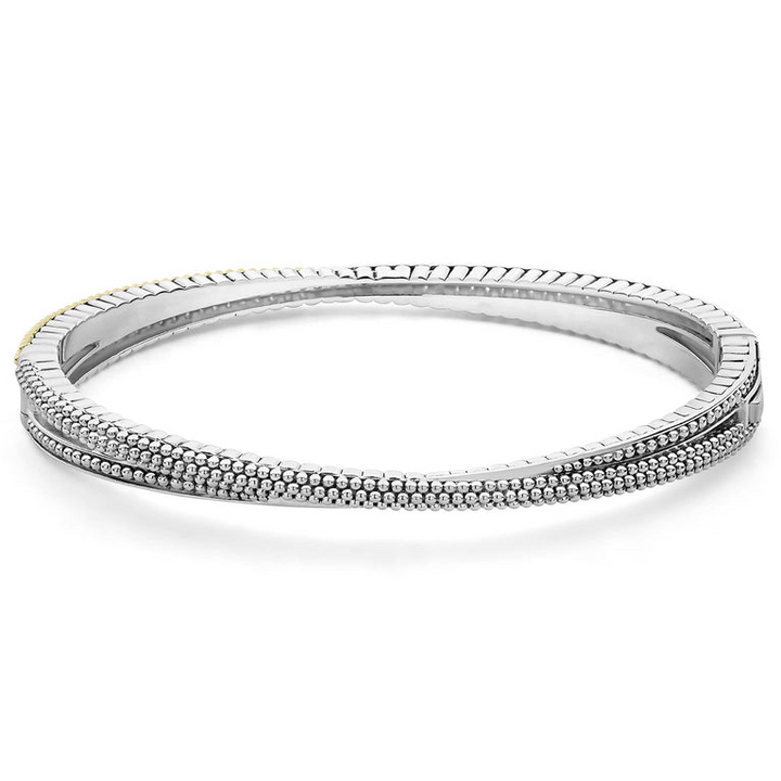 A Sterling Silver & 18k gold bracelet opened in the middle of a white background. The bracelet has caviar beading with an X design.