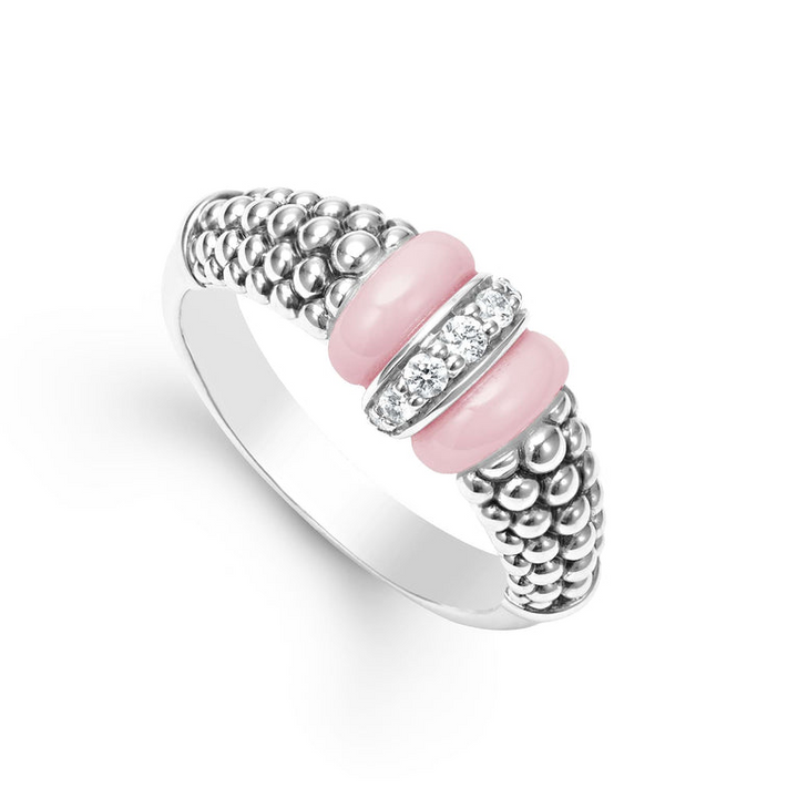 A sterling silver ring is displayed angled on a white background featuring pink ceramic caviar beading with a row of diamonds.