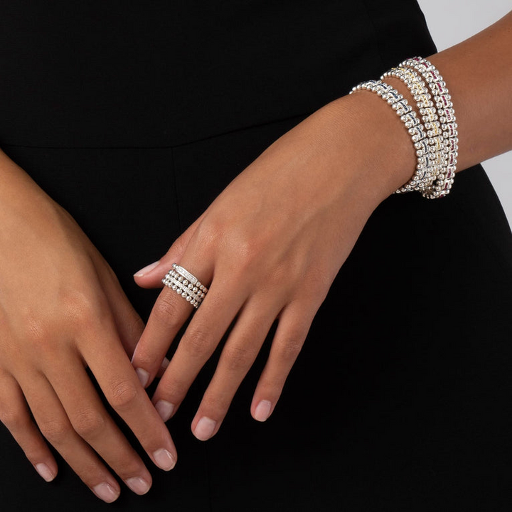 A woman is wearing a Sterling silver link bracelet featuring ruby gemstones and caviar bead links.