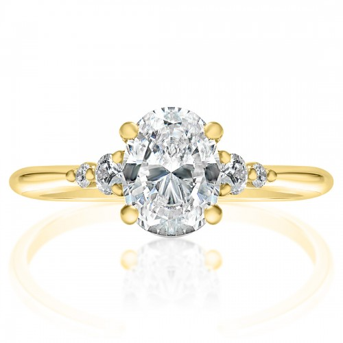 The Five Stone Engagement Ring, made of yellow gold, lies flat against a white background. It features an oval-cut diamond set in the center with round-shaped side stones. 