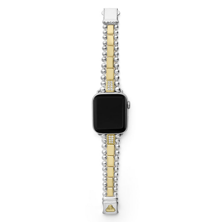 An Apple watch rests in the middle, showcasing the LAGOS engraved clasp against a white background. The watch band features 18K gold-stationed links and stainless steel beading around the links.