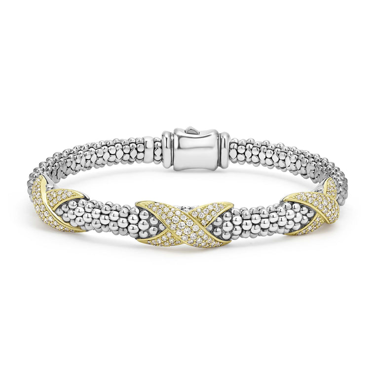 A Sterling Silver & 18k gold bracelet resting in the middle of a white background. The bracelet features diamond-set X stations, caviar beading, and a stainless steel clasp.