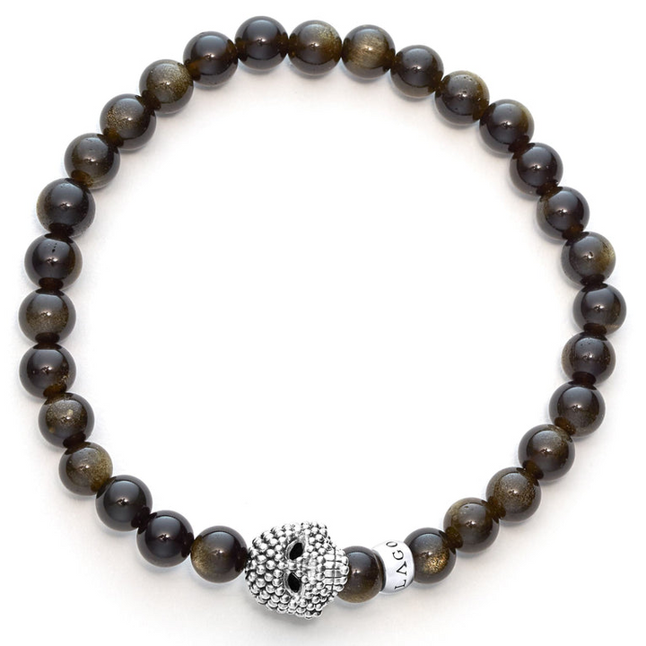 A sterling silver bracelet is displayed in the middle of a white background featuring a Golden Obsidian gemstone beaded bracelet with a sterling silver Caviar skull.