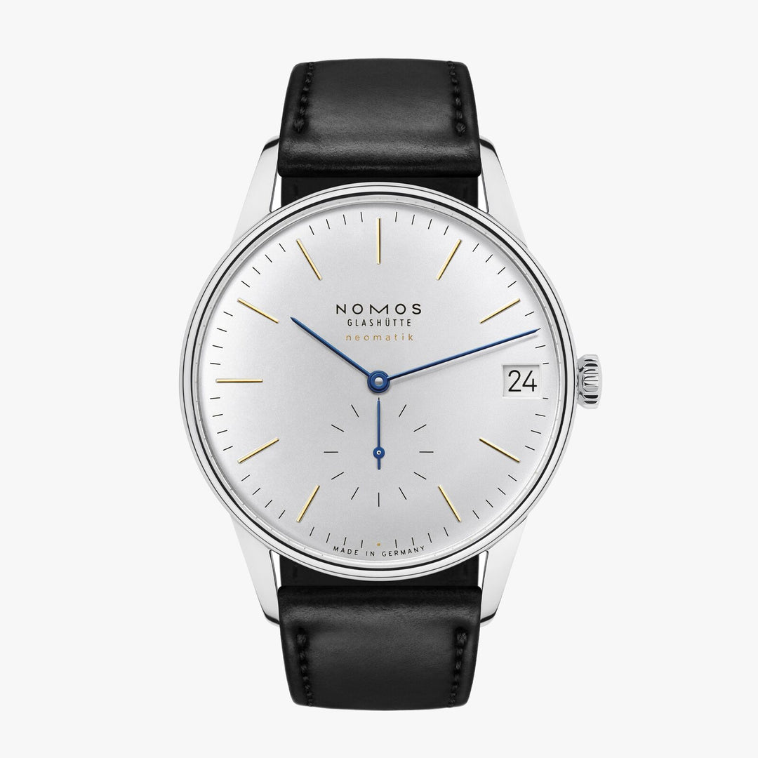 A Nomos Glashutte watch stands straight against a white background. It features a white dial, gold & blue hands and markers, a stainless steel bezel, and a black strap.