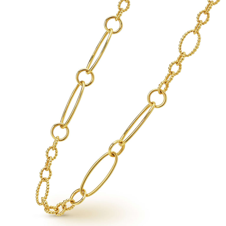 A close-up of an 18k gold link necklace angled to the right featuring caviar beading and fluting elements.