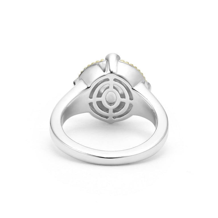 A back-view of a sterling silver and 18k gold ring displayed in the middle of a white background featuring a freshwater cultured pearl surrounded by sterling silver, diamonds, and 18K gold