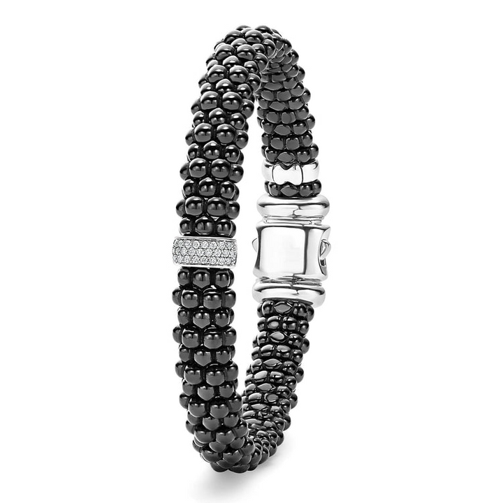 A sterling silver bracelet standing vertically in the middle of a white background featuring diamonds is set in sterling silver and surrounded by black ceramic Caviar beading.