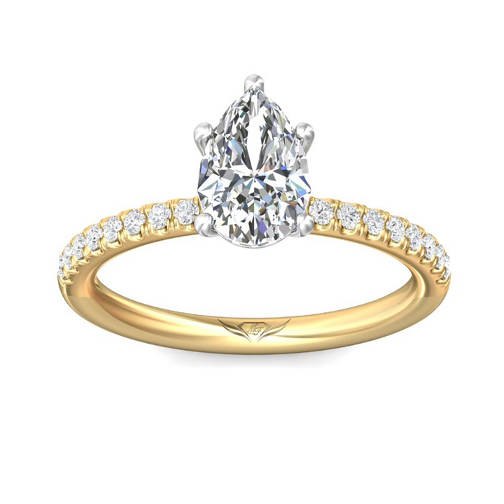 The Half Eternity Engagement Ring is made of yellow gold, tilted forward against a white background. It features a pear-cut diamond set in the center with a mircopave diamond set band. Showing the "Martin Flyer" inscription is visible inside the band.