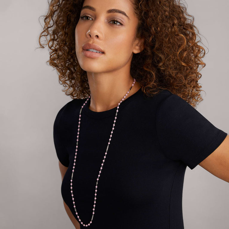 A woman wearing a sterling silver and ceramic beaded necklace featuring Pink ceramic and silver Caviar beading.