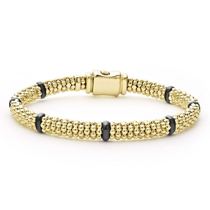 An 18k gold bracelet resting in the middle of a white background. The bracelet features smooth black stations, caviar beading, and gold clasp.