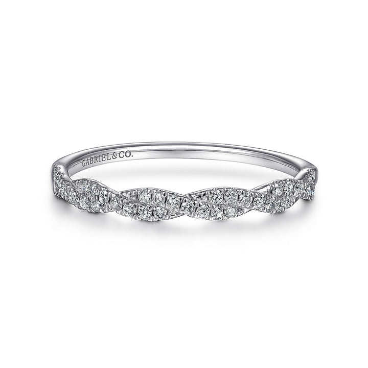 A white gold ring lies flat against a white background. The band features a twist design with diamonds.