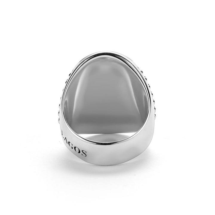 A back-view of a sterling silver ring in the middle of a white background featuring a skull motif on the signet ring