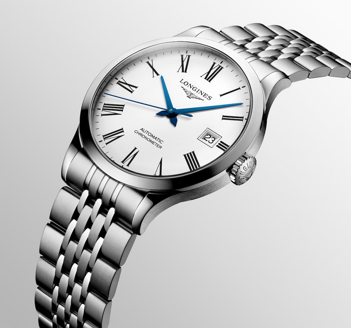 Close-up of a Longines watch, highlighting the right side profile and bracelet. The watch features a silver dial, black & blue hands and markers, a stainless steel bezel, a crown on the right side, and a brown leather strap.