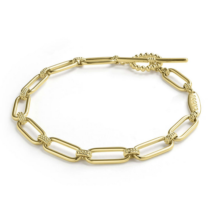 An 18K gold link bracelet angled laying in the middle with a white background, featuring caviar beading and fluting elements 