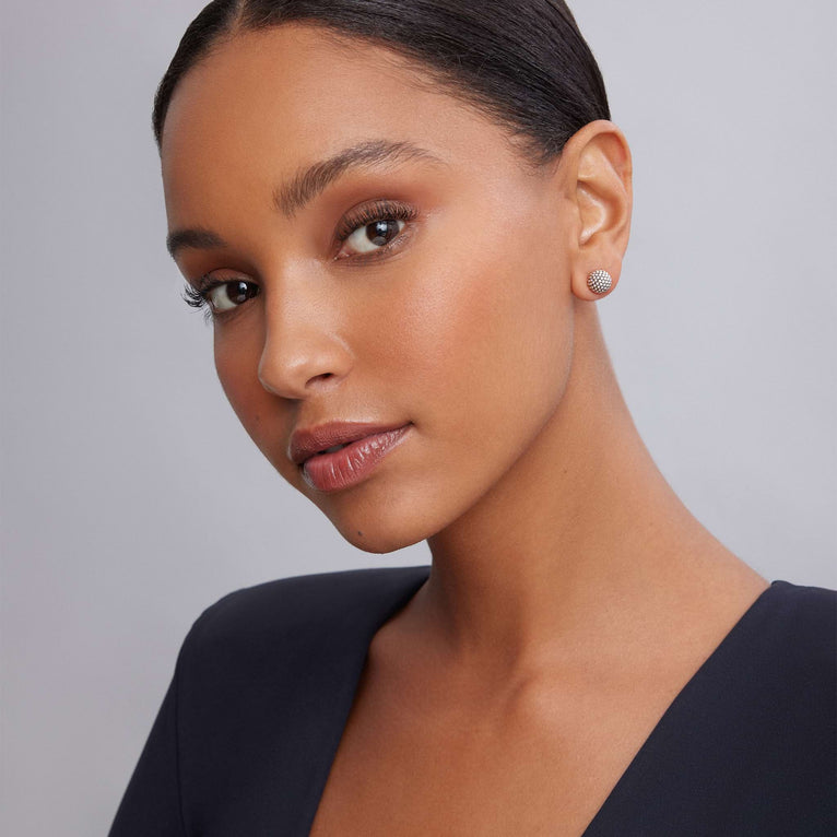 A woman wearing a black top and stud earrings with Classic Caviar beads in sterling silver.