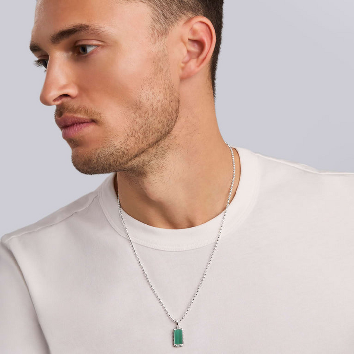 A man wearing a white shirt and a Malachite Tag Amulet with a chain necklace with a Malachite gemstone