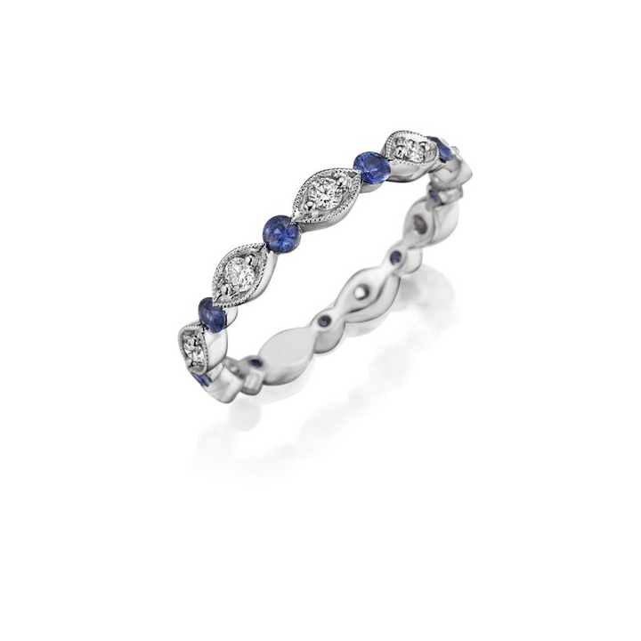 This is a close-up of a white gold ring angled to the left. It shows the inside of the band against a white background. The ring features a diamond-set band with marquise and sapphire detailing.