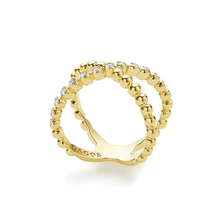 A side view of an 18K Gold ring against a white background featuring caviar beading and an X design.