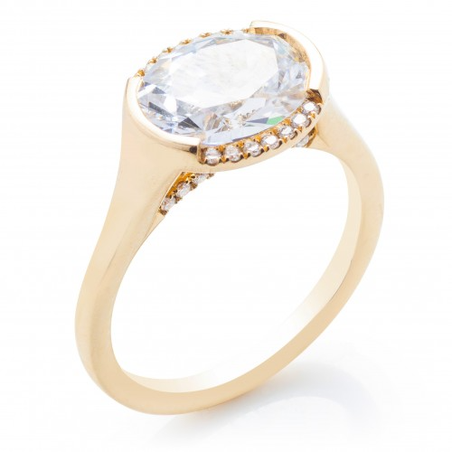 A close-up of the Oval East West Semi Halo Engagement Ring, made of yellow gold, angled to the right against a white background. It features an oval-cut diamond set in the center with a semi-halo of diamonds