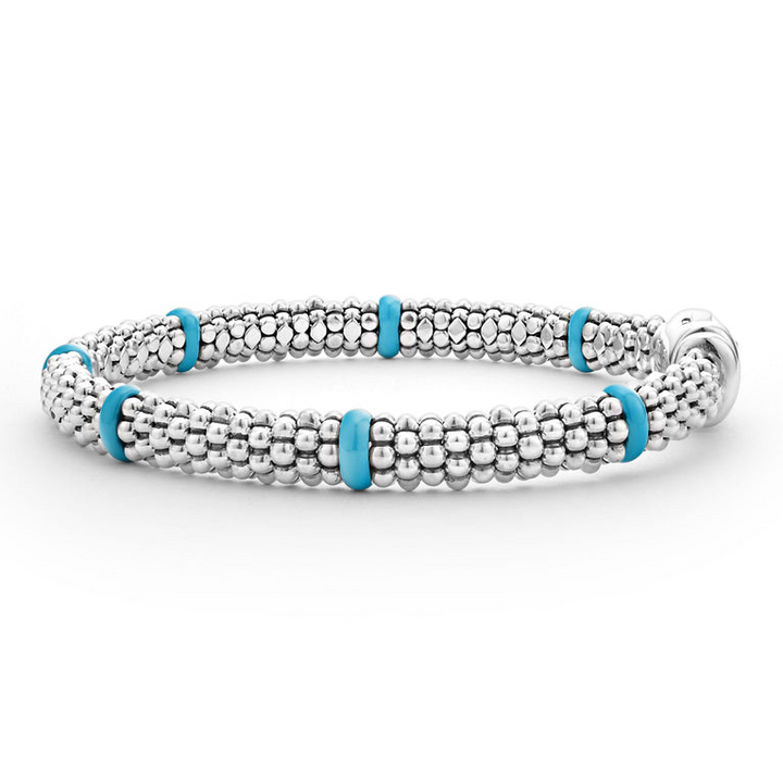 A side-view of a Sterling Silver & 18K Gold bracelet in the middle of a white background, featuring seven sterling silver stations and blue caviar beading