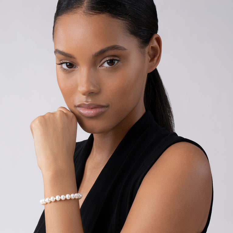 A woman is wearing a bracelet featuring a single strand of cultured freshwater pearls