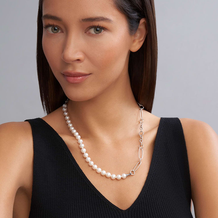 A close-up of a woman wearing a sterling silver necklace featuring cultured freshwater pearl stations highlighted with Caviar beading