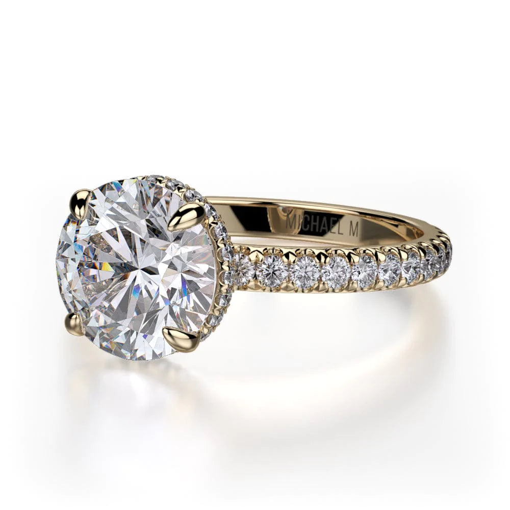 Angled view of a Michael M. yellow gold engagement ring showing the round center stone and pavé diamond shoulders.