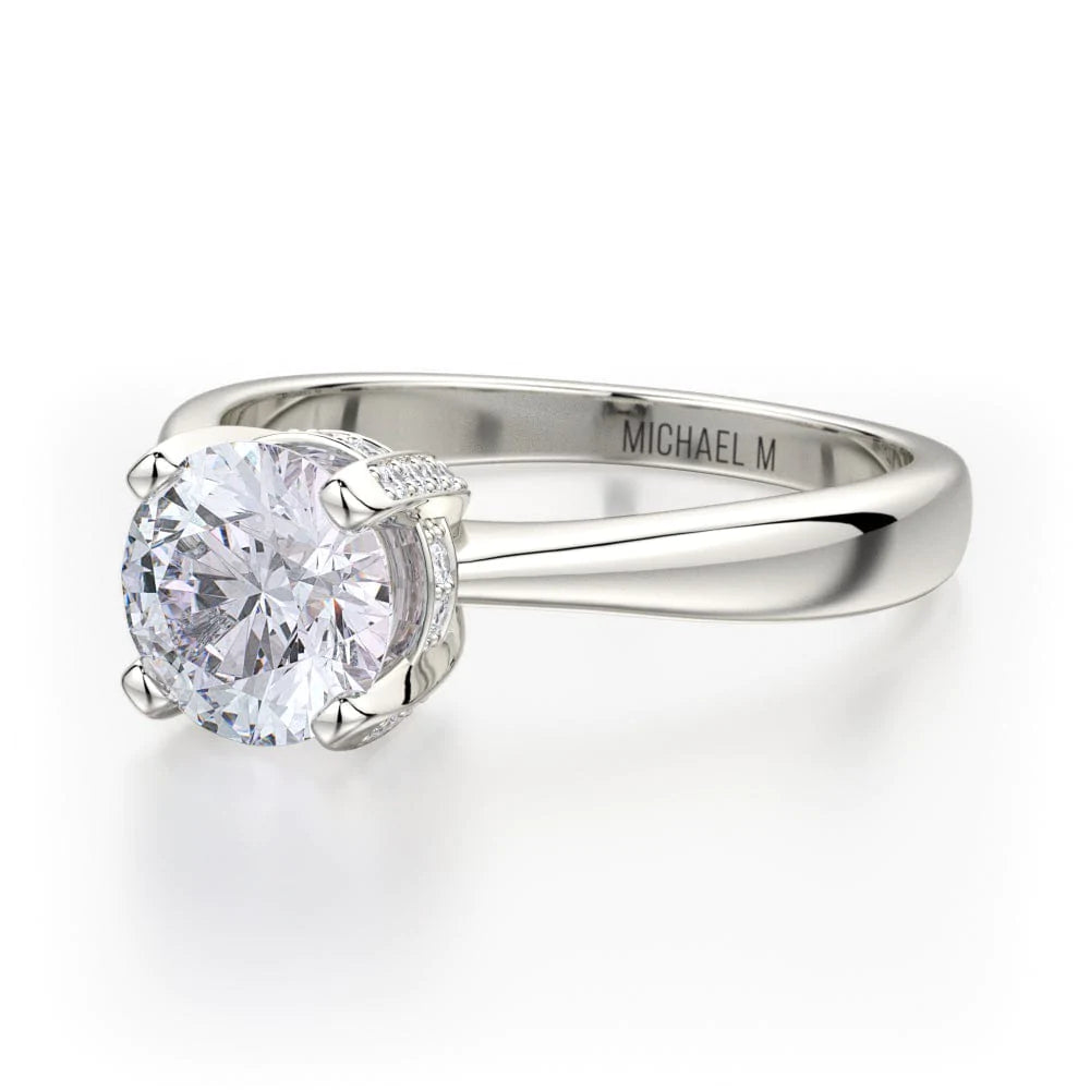 Angled view of a Michael M. engagement ring showing the round center stone, pavé diamond basket and polished band.