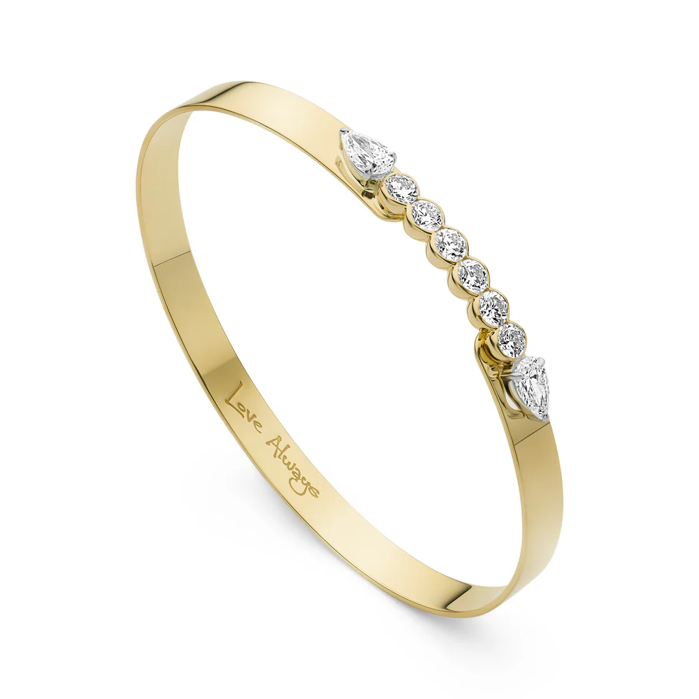 Close up side view of Phillips House Yellow Gold Love Always Bracelet, with Love Always engraved on the inside of the bracelet on a white background.