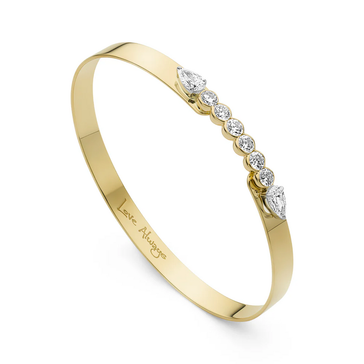 Close up side view of Phillips House Yellow Gold Love Always Bracelet, with Love Always engraved on the inside of the bracelet on a white background.