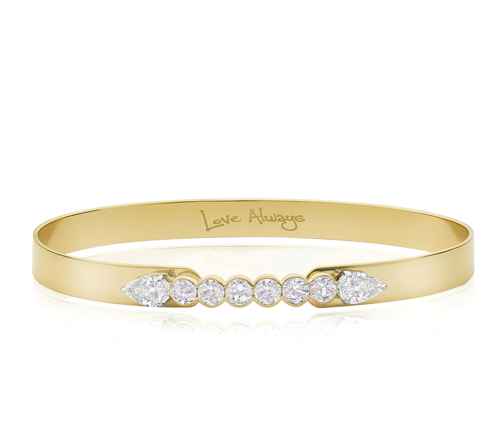 Close up of Phillips House Yellow Gold Love Always Bracelet, with Love Always engraved on the inside of the bracelet on a white background.