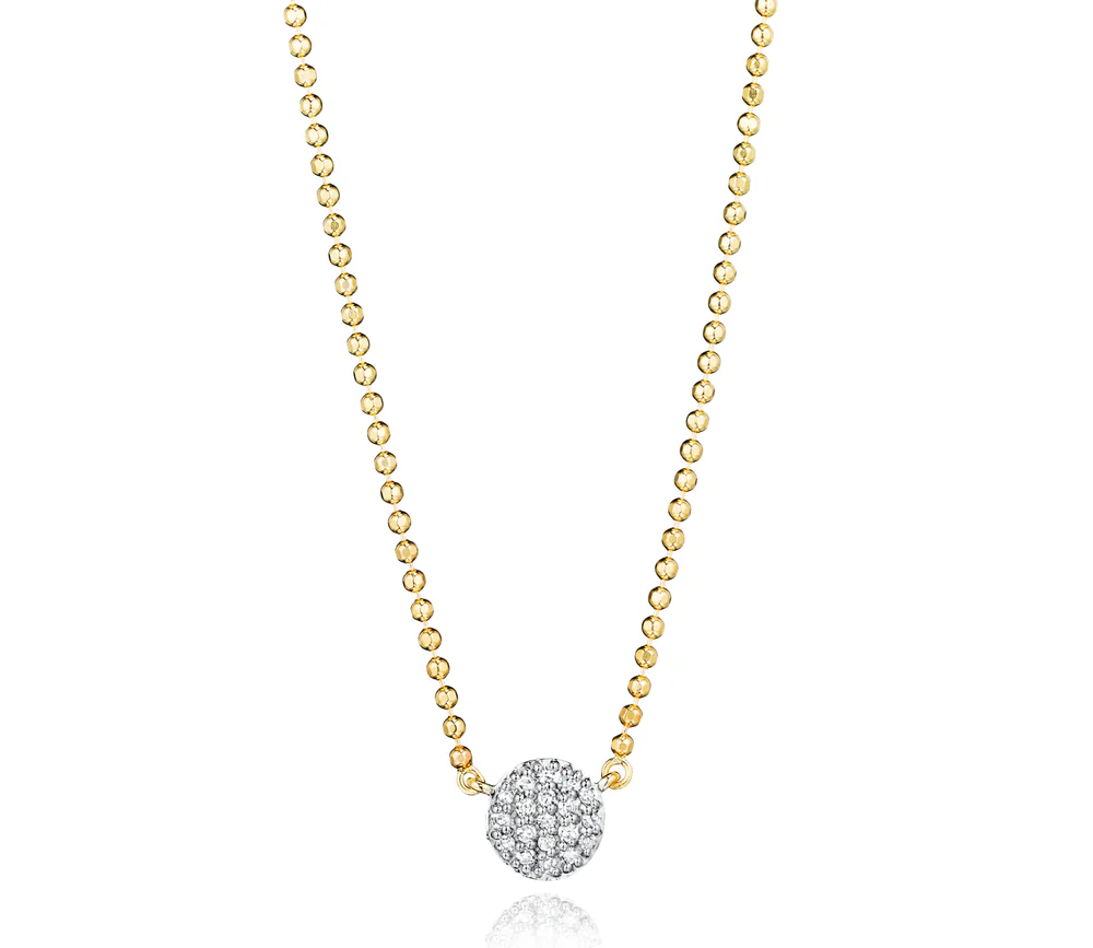 Up close yellow gold necklace with a small diamond pavé disc on a white background.