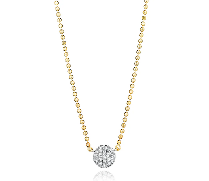 Up close yellow gold necklace with a small diamond pavé disc on a white background.