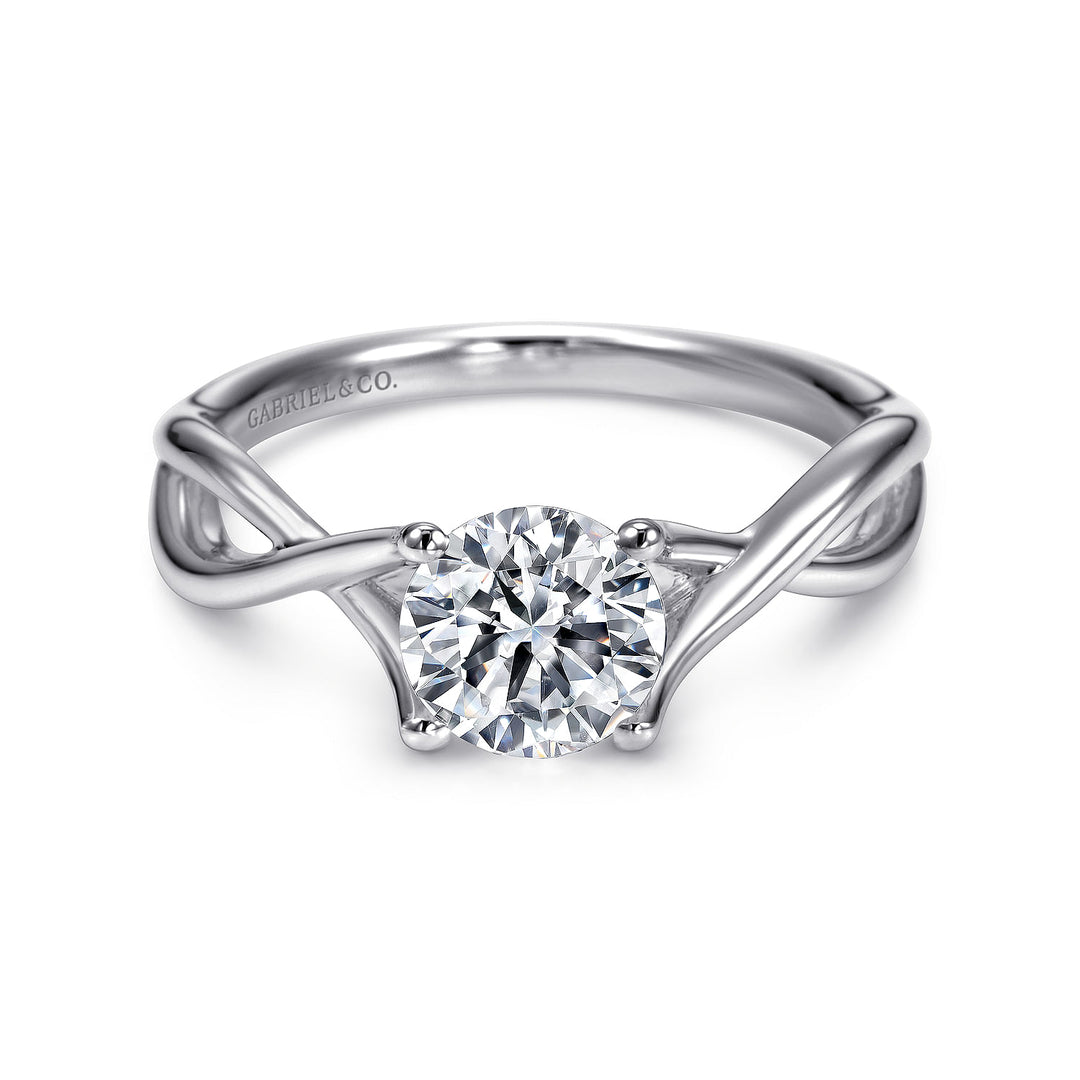 Front view of a white gold solitaire engagement ring with a round center stone and intertwined polished shoulders.