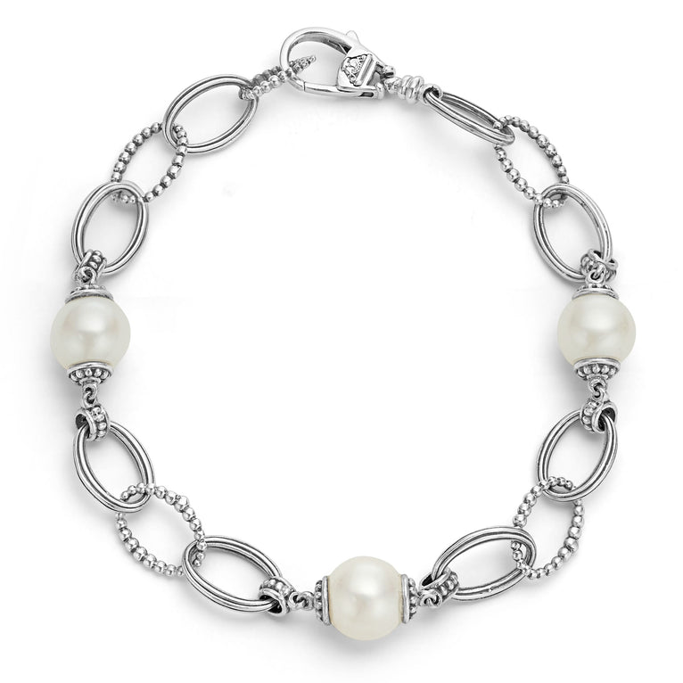 A Sterling Silver link bracelet rests in the middle of a white background. It has three cultured freshwater pearl stations and caviar-beaded links.