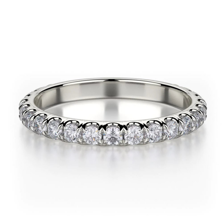 A white gold ring lies flat against a white background. The ring features a continuous row of clear, round-cut diamonds.