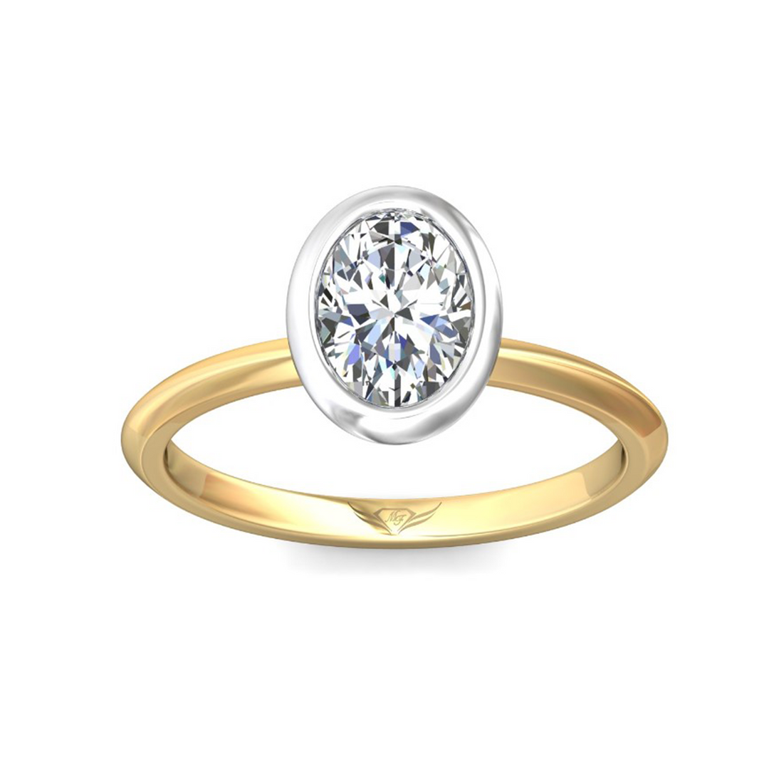 The Bezel-Set Engagement Ring is made of yellow gold, tilted up against a white background. It features an oval-cut diamond set in the center with a white gold bezel setting. Showing the "Martin Flyer" inscription is visible inside the band