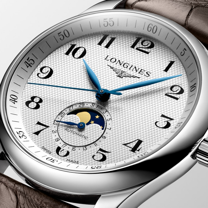 A close-up of a Longines watch highlighting the silver dial and crown. 