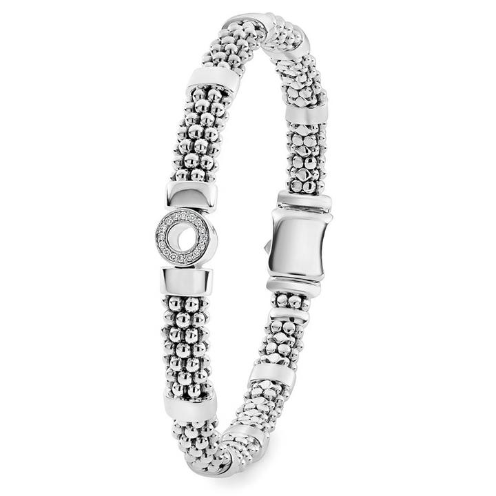 A sterling silver bracelet standing vertically in the middle of a white background featuring one diamond circle station and caviar beading.