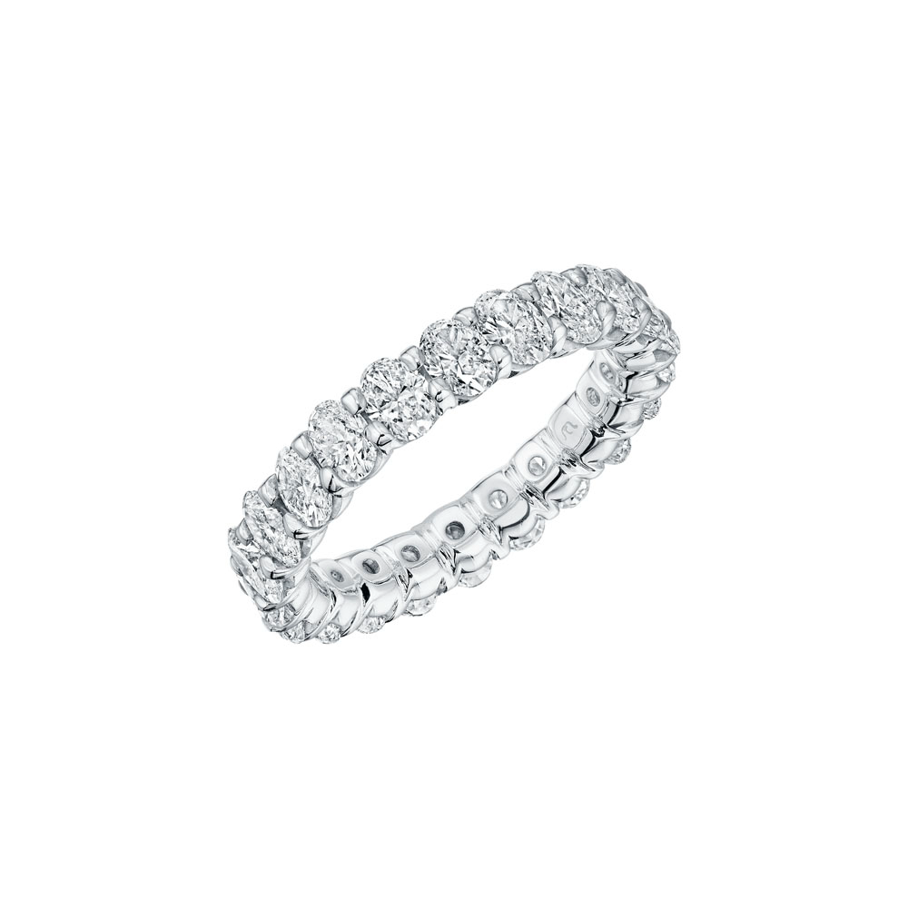 Close-up photo of a white gold women's wedding band angled to the right with oval cut diamonds on a white background