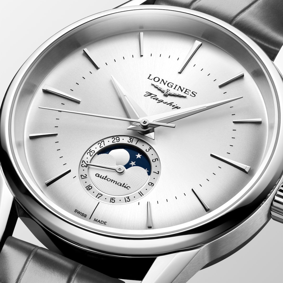 A close-up of a Longines watch highlighting the silver dial and crown. 