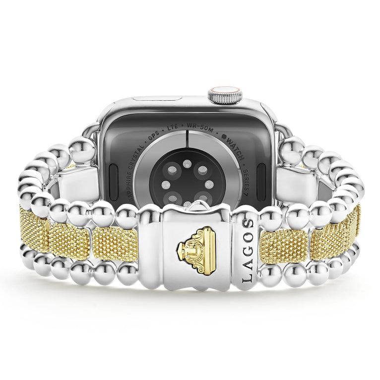 An Apple watch rests in the middle, showcasing the LAGOS engraved clasp against a white background. The watch band features 18K gold-stationed links and stainless steel beading around the links.