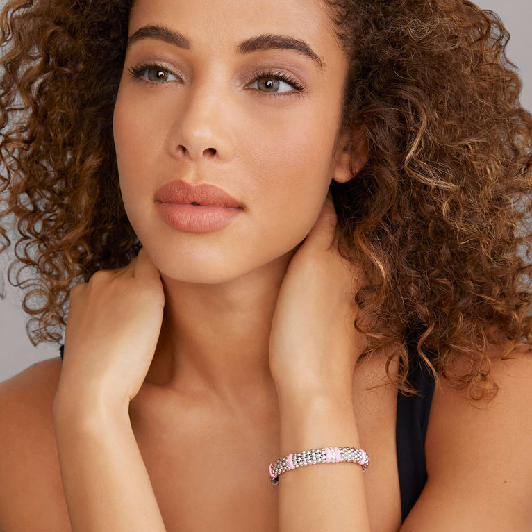 A woman wearing a sterling silver & 18k gold bracelet featuring pink ceramic and Caviar beading.